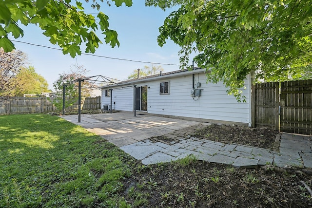 back of property with a lawn, a patio, and a fenced backyard