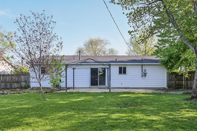 back of house with fence, a lawn, and a patio area