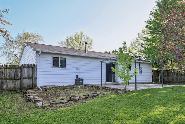 rear view of property featuring a yard, a patio, and fence