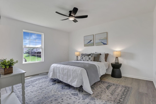 bedroom featuring a ceiling fan, wood finished floors, and baseboards