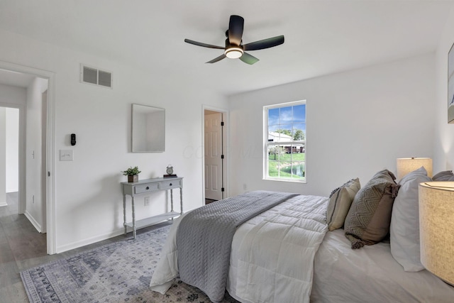 bedroom with visible vents, ceiling fan, wood finished floors, and baseboards