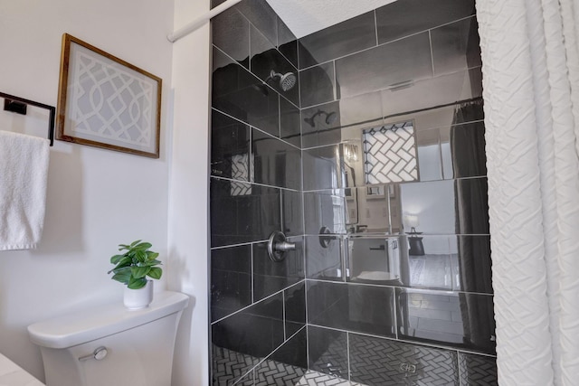 bathroom with toilet and a shower stall