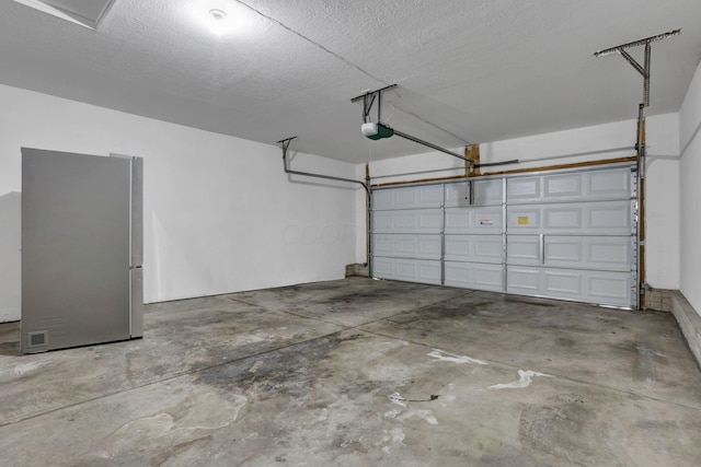 garage with freestanding refrigerator and a garage door opener