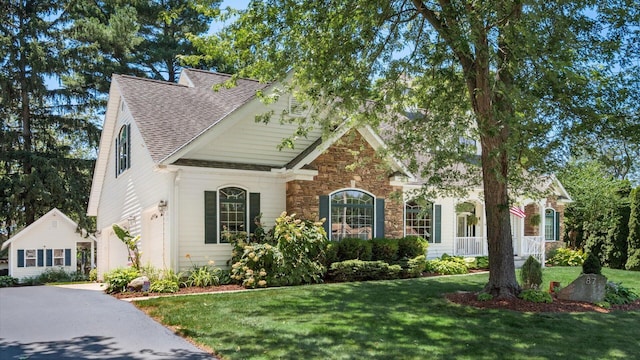 87 Dartmouth Rd SE, Hebron, OH 43025 - view of front of home with a garage, a front lawn, a shingled roof, and stone siding