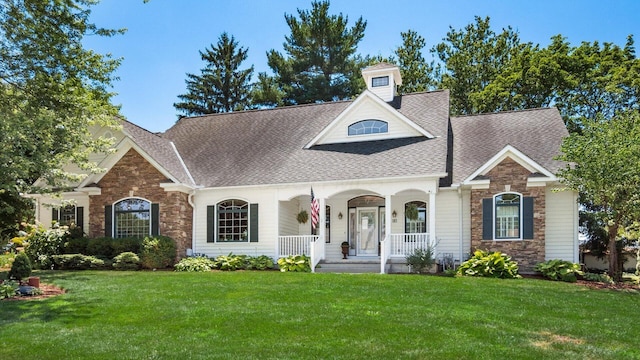 87 Dartmouth Rd SE, Hebron, OH 43025 - view of front of home with a front yard, stone siding, covered porch, and a shingled roof