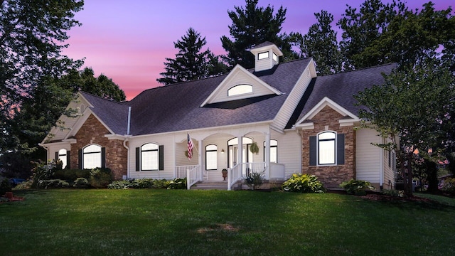 87 Dartmouth Rd SE, Hebron, OH 43025 - view of front of house with a lawn, roof with shingles, a porch, and stone siding