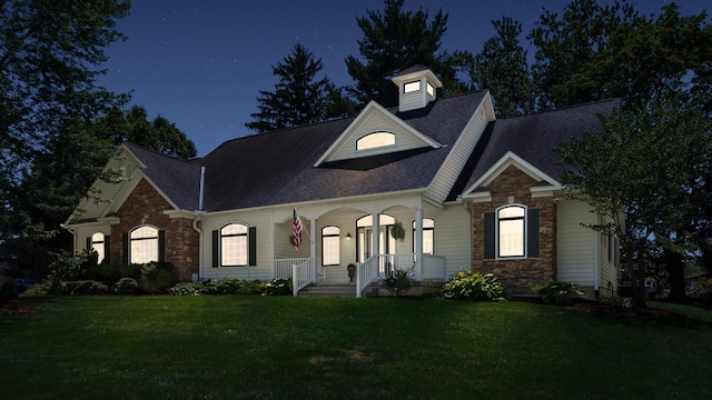 87 Dartmouth Rd SE, Hebron, OH 43025 - view of front facade featuring a front yard, roof with shingles, a porch, and stone siding