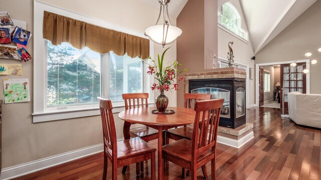 87 Dartmouth Rd SE, Hebron, OH 43025 - dining room featuring a fireplace, dark wood-style flooring, high vaulted ceiling, and baseboards