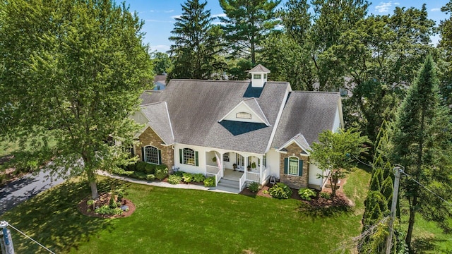 87 Dartmouth Rd SE, Hebron, OH 43025 - view of front facade featuring covered porch, roof with shingles, a front lawn, and stone siding