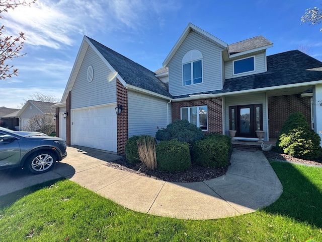 view of front of home with roof with shingles, a garage, driveway, and brick siding