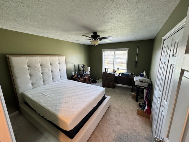 carpeted bedroom featuring a textured ceiling and a ceiling fan