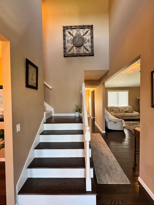 stairway with wood finished floors and baseboards