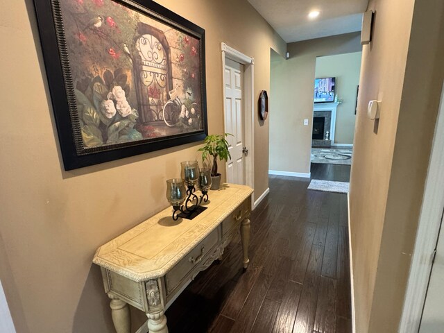 corridor with baseboards and dark wood finished floors