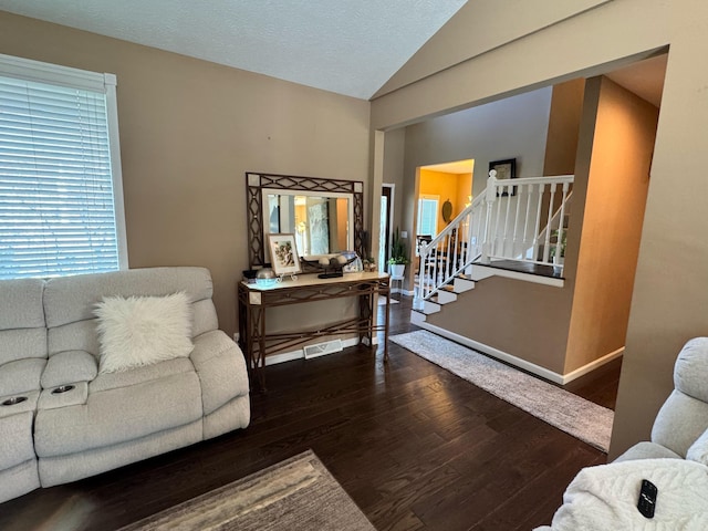 living room with visible vents, vaulted ceiling, wood finished floors, and baseboards