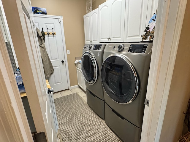 laundry area featuring light tile patterned floors, cabinet space, and independent washer and dryer