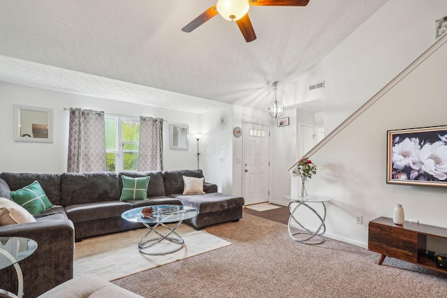 living room with visible vents, a ceiling fan, a textured ceiling, and carpet