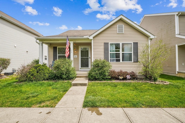 bungalow-style home with covered porch and a front lawn