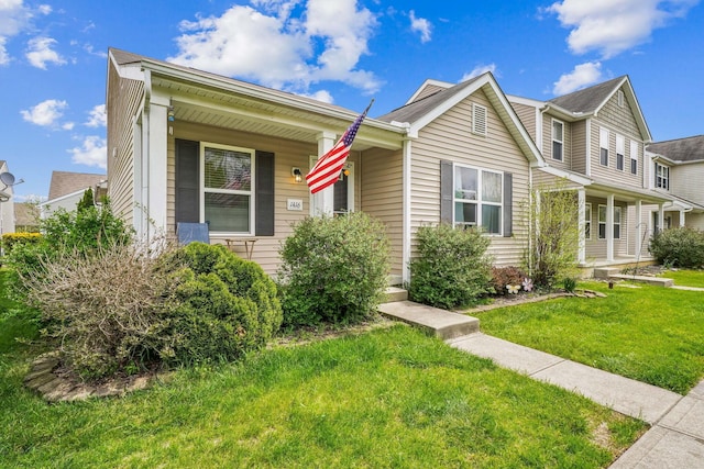 view of front of home with covered porch and a front lawn