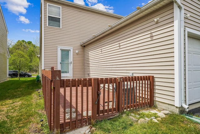 view of property exterior featuring a deck, a lawn, and an attached garage