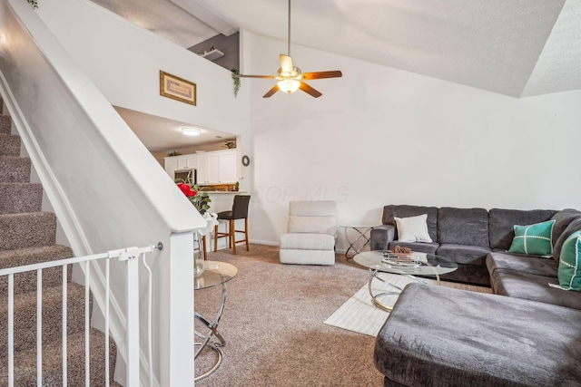 living area featuring ceiling fan, lofted ceiling with beams, baseboards, light carpet, and stairs