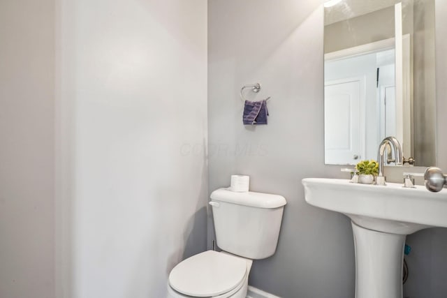 bathroom with toilet and baseboards