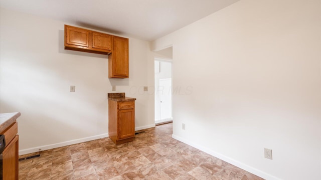 kitchen with visible vents, brown cabinets, and baseboards