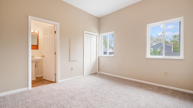 unfurnished bedroom featuring connected bathroom, a closet, carpet, and baseboards
