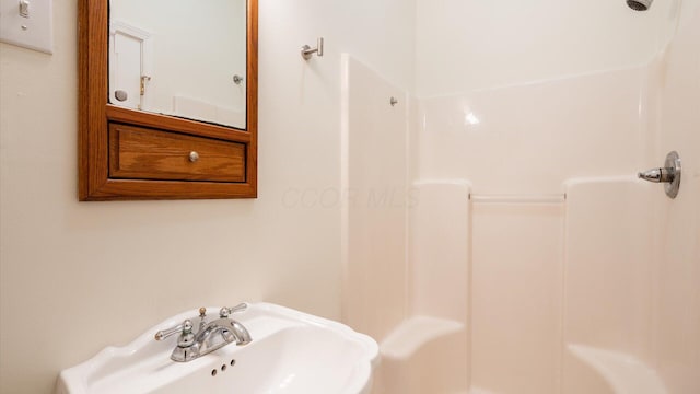 full bathroom featuring walk in shower and a sink