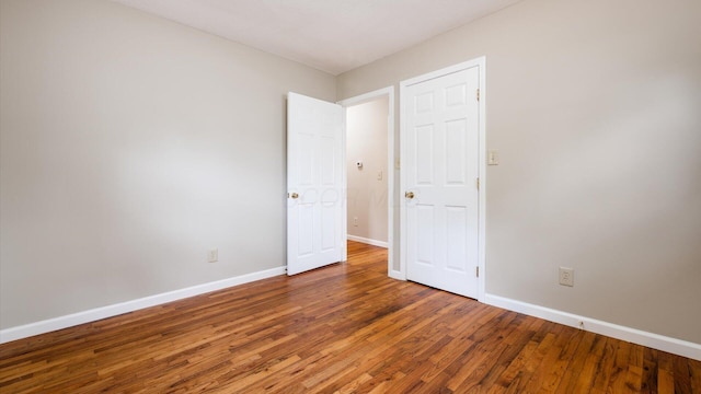 empty room with baseboards and wood finished floors