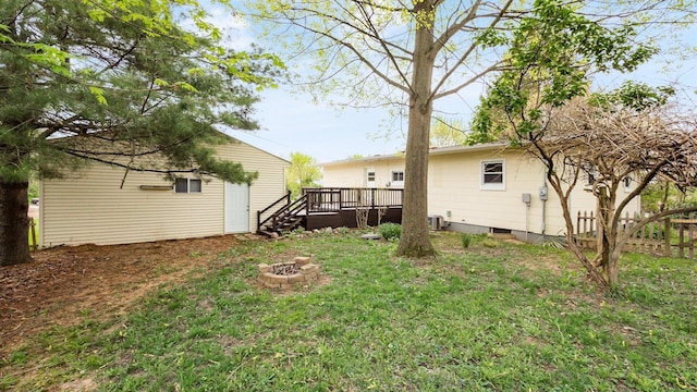 view of yard featuring a fire pit, fence, a wooden deck, and cooling unit