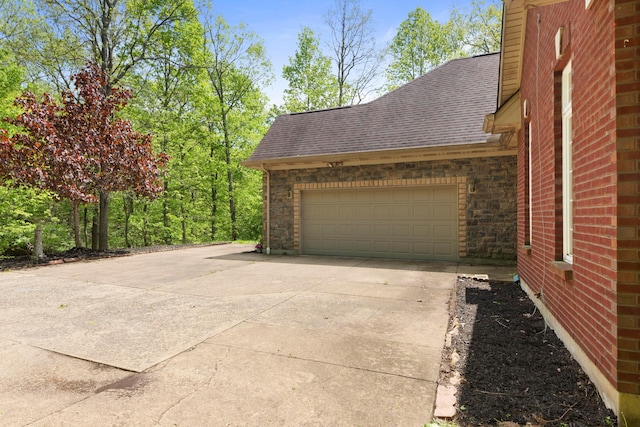 4611 Meghans Run, Batavia, OH 45103 - view of side of home featuring roof with shingles, an attached garage, driveway, and brick siding