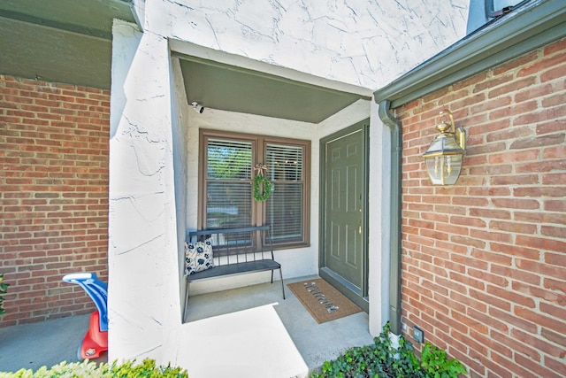 entrance to property featuring brick siding