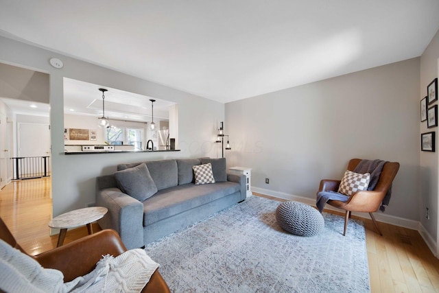 living room featuring light wood-style floors, baseboards, and recessed lighting