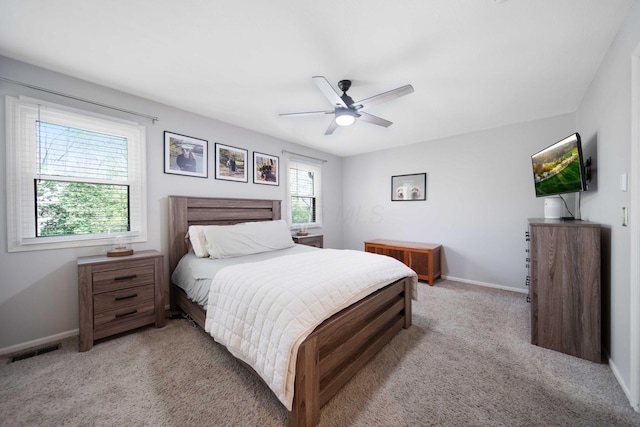bedroom featuring visible vents, a ceiling fan, baseboards, and light carpet