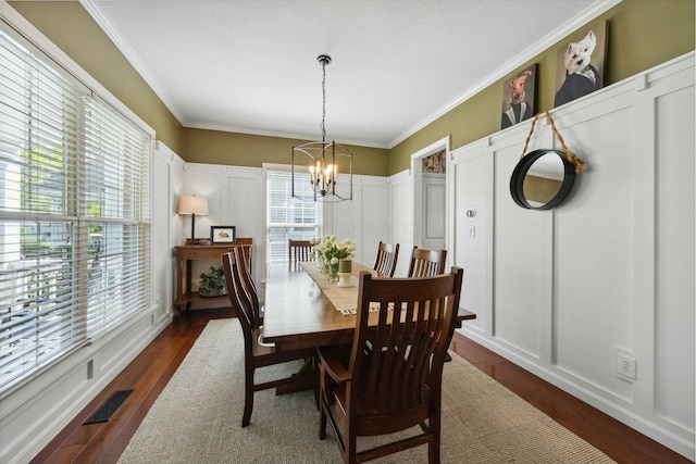 6767 Burnside Ln, Dublin, OH 43016 - dining area featuring dark wood-style floors, ornamental molding, a notable chandelier, and a decorative wall