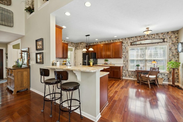 6767 Burnside Ln, Dublin, OH 43016 - kitchen featuring a healthy amount of sunlight, a peninsula, black fridge, and baseboards