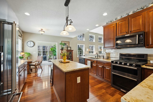 6767 Burnside Ln, Dublin, OH 43016 - kitchen featuring decorative backsplash, a sink, stainless steel appliances, a kitchen island, and dark wood-style flooring