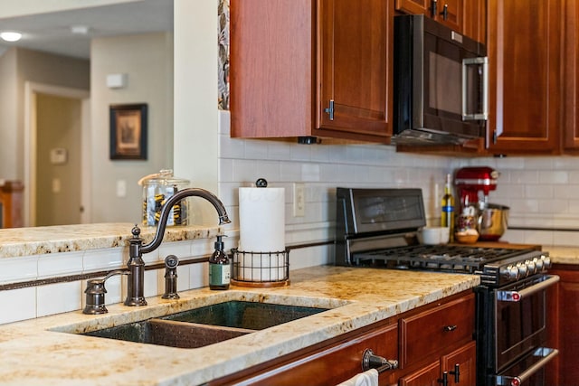 6767 Burnside Ln, Dublin, OH 43016 - kitchen featuring double oven range, a sink, light stone counters, and decorative backsplash