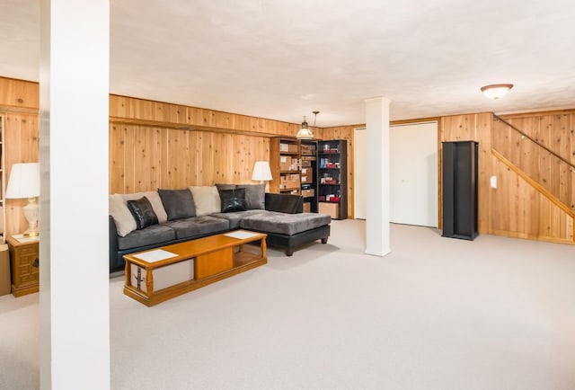 carpeted living room with wooden walls and stairs