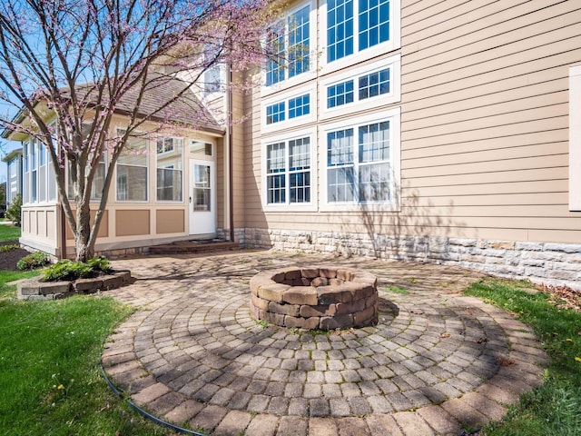 rear view of property featuring a patio and a fire pit