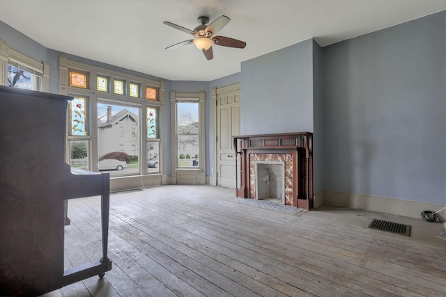 423 Hudson Ave, Newark, OH 43055 - unfurnished living room with visible vents, ceiling fan, a premium fireplace, and wood-type flooring