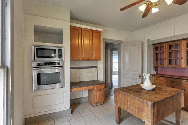 423 Hudson Ave, Newark, OH 43055 - kitchen with light tile patterned floors, dark countertops, stainless steel appliances, a ceiling fan, and brown cabinetry