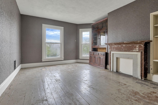 423 Hudson Ave, Newark, OH 43055 - unfurnished living room featuring visible vents, a textured wall, light wood finished floors, and baseboards