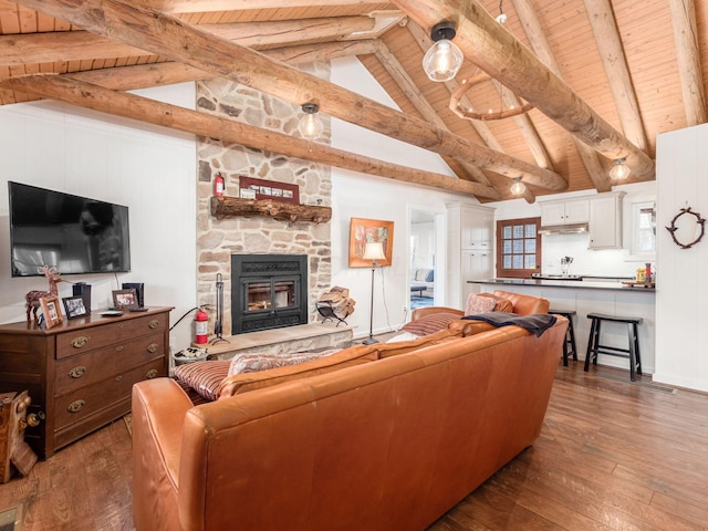 living room with beam ceiling, wood-type flooring, high vaulted ceiling, a stone fireplace, and wooden ceiling