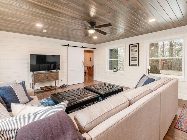 living area featuring plenty of natural light, a barn door, wood ceiling, and wood finished floors