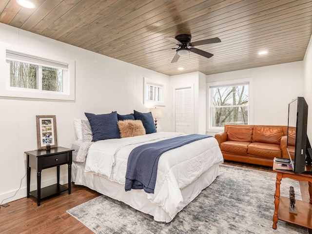 bedroom with wooden ceiling, multiple windows, and wood finished floors