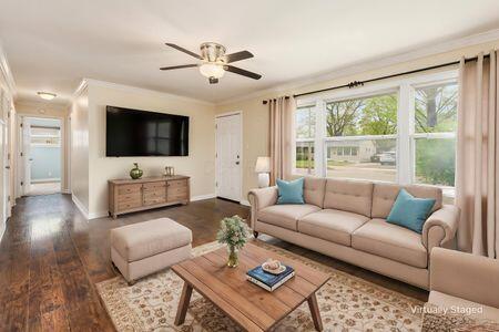 living room featuring crown molding, baseboards, ceiling fan, and wood finished floors