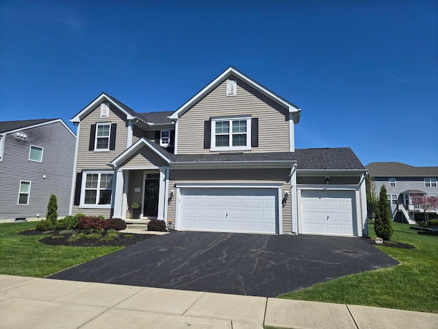 view of front facade with a front lawn, driveway, and a garage