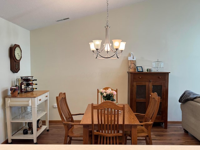 dining area with an inviting chandelier, baseboards, wood finished floors, and visible vents