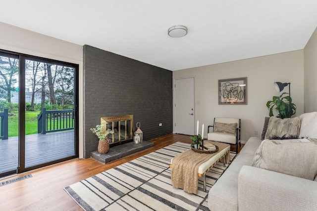 living area featuring visible vents, wood finished floors, and a fireplace